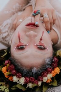 Woman crying tears of blood with a crown of flowers.